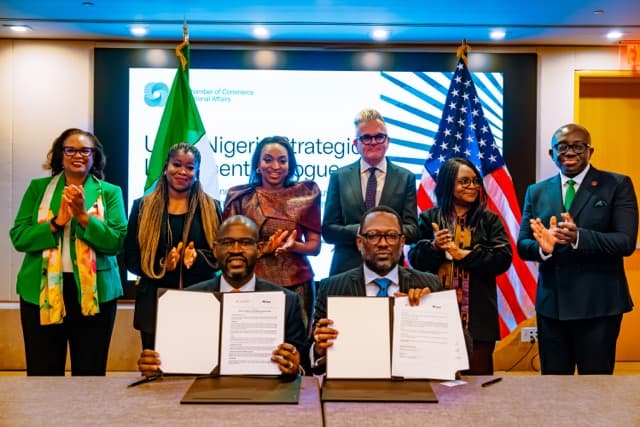 A signing ceremony at the U.S.–Nigeria Strategic Investment Dialogue, delegates standing behind the table beneath the Nigerian and American flags